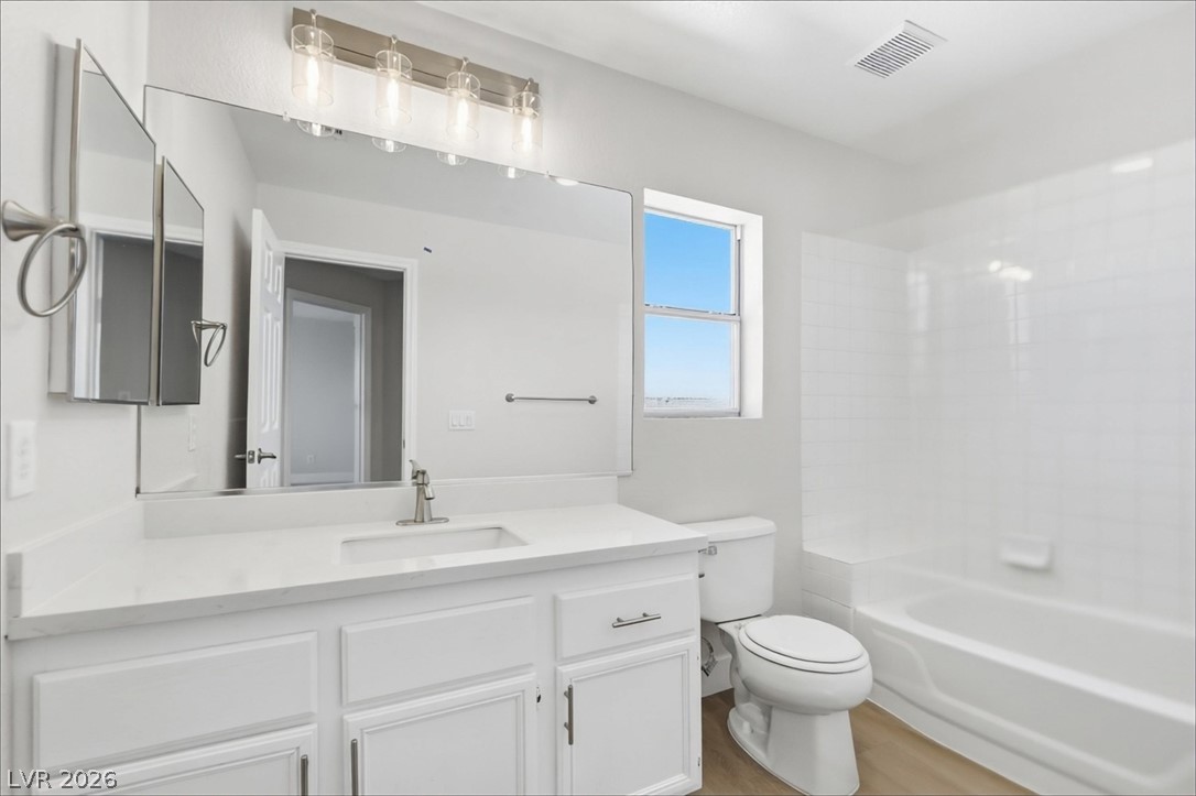 1906 Cardinal Point Street Henderson, NV 89012 - Photo 18 of 20 Natural light from a classic window brightens a modern washroom with plank flooring.