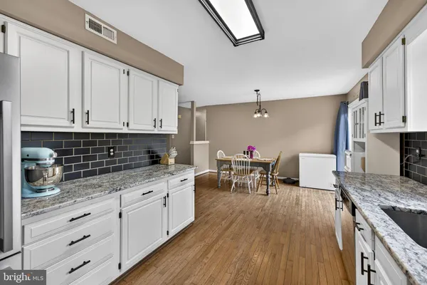 a kitchen with granite countertop white cabinets and white appliances