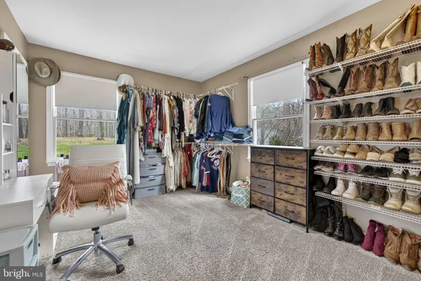 a view of walk in closet with clothes and shoes