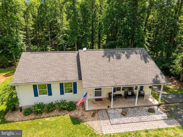an aerial view of a house with swimming pool next to a yard