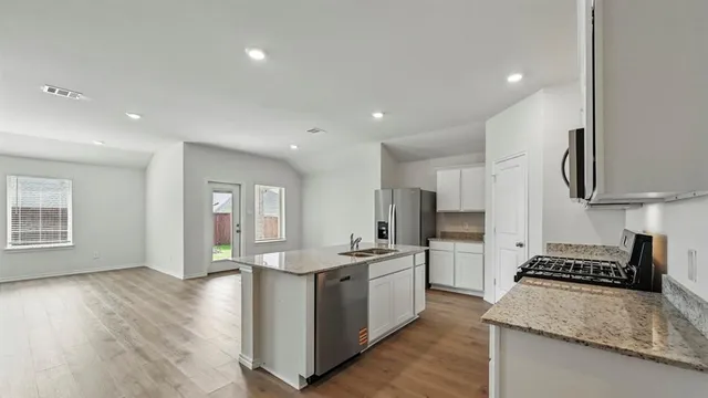 a kitchen with a sink a microwave a refrigerator and cabinets