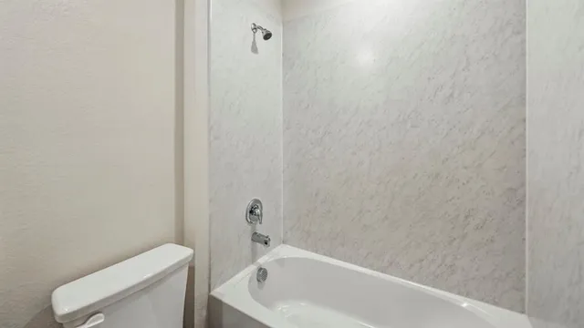 a bathroom with a toilet and bathtub