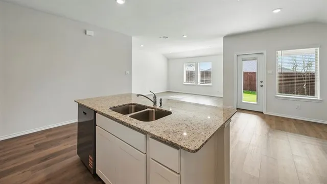 a kitchen with stainless steel appliances granite countertop a sink and stove top oven