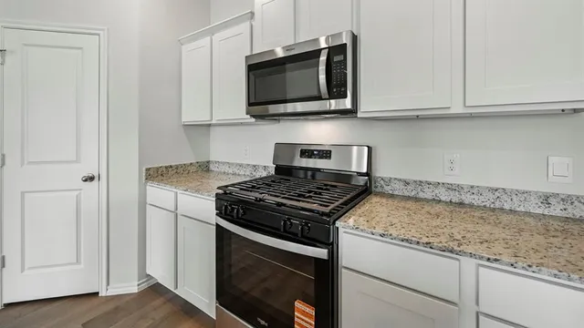 a kitchen with a stove a sink and a microwave