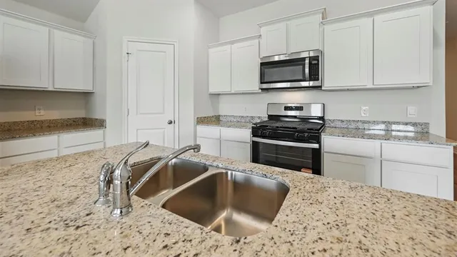 a kitchen with stainless steel appliances kitchen island granite countertop a stove and a refrigerator