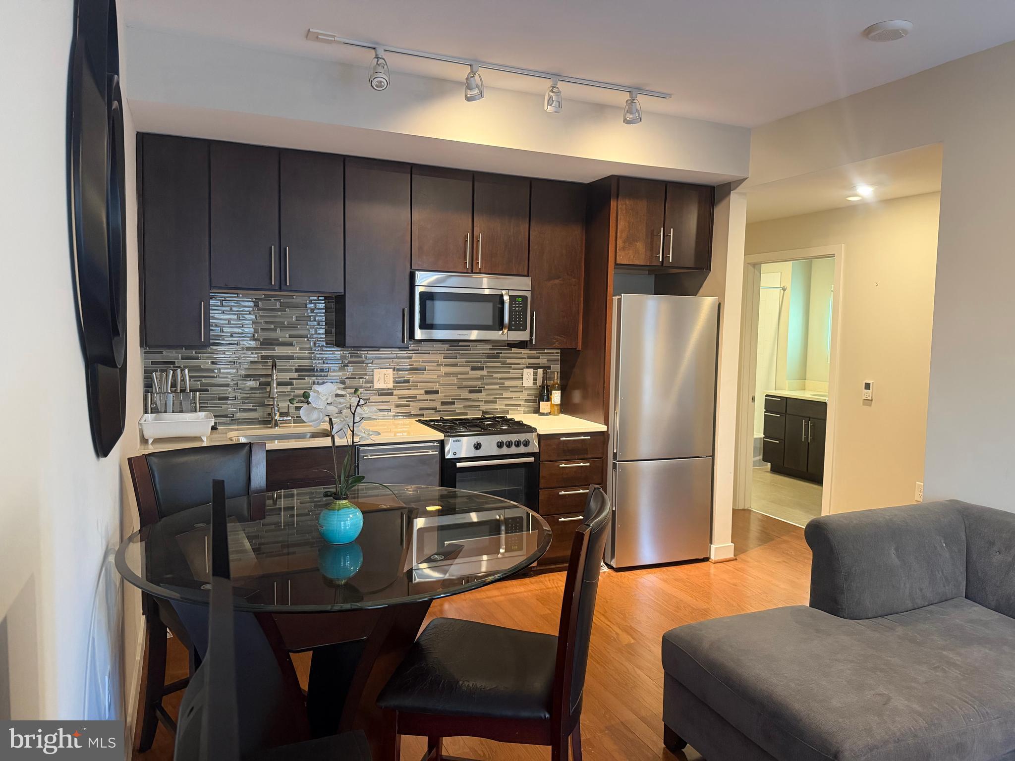 1320 Fenwick Lane, Unit 700 Silver Spring, MD 20910 - Photo 17 of 26 a kitchen with stainless steel appliances granite countertop a kitchen island a table and chairs