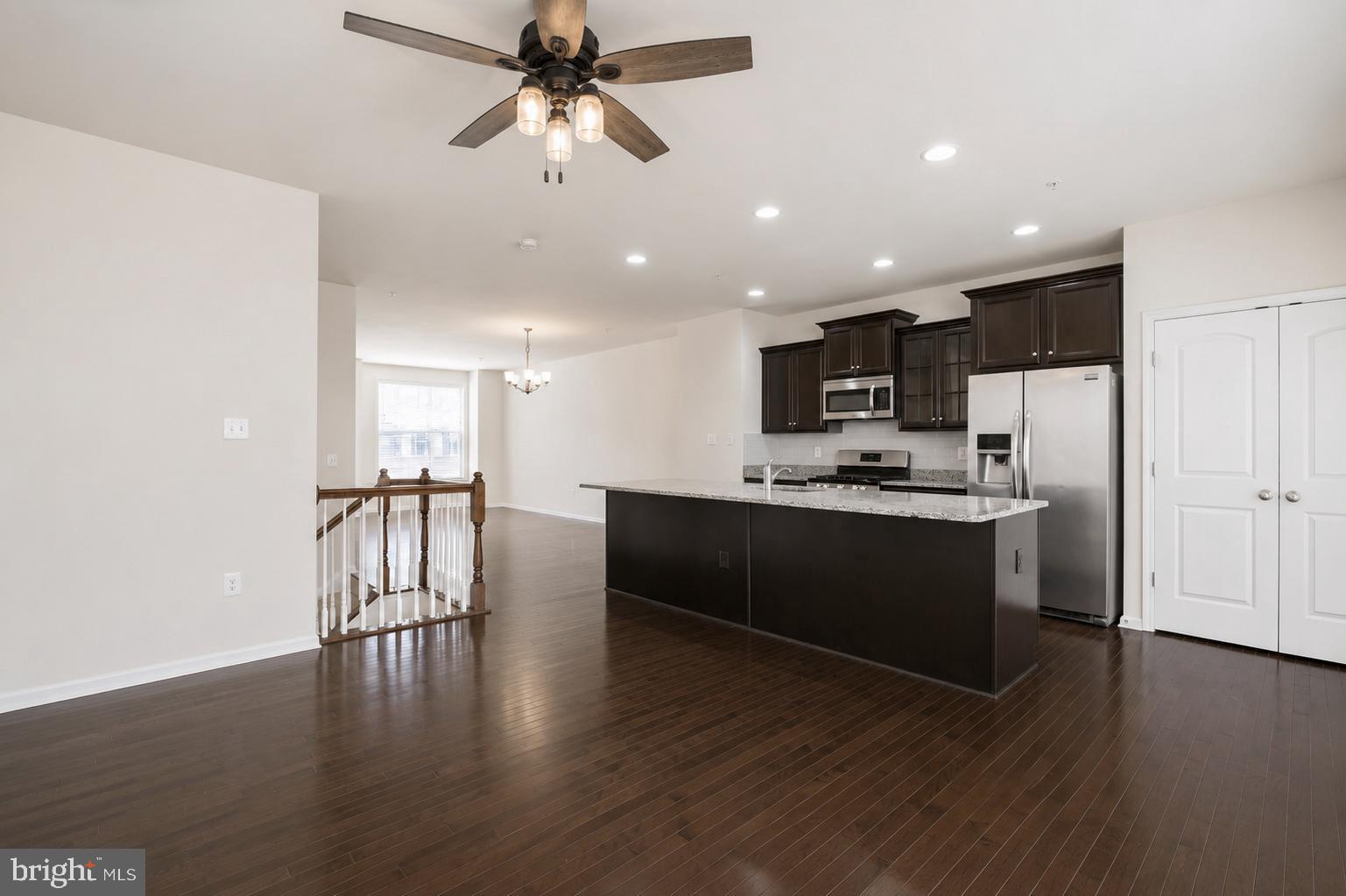 4731 Cambria Road Frederick, MD 21703 - Photo 23 of 63 a kitchen with stainless steel appliances kitchen island granite countertop a refrigerator a stove a microwave oven a sink with white cabinets and wooden floor