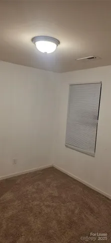 an empty room with a space and mirror