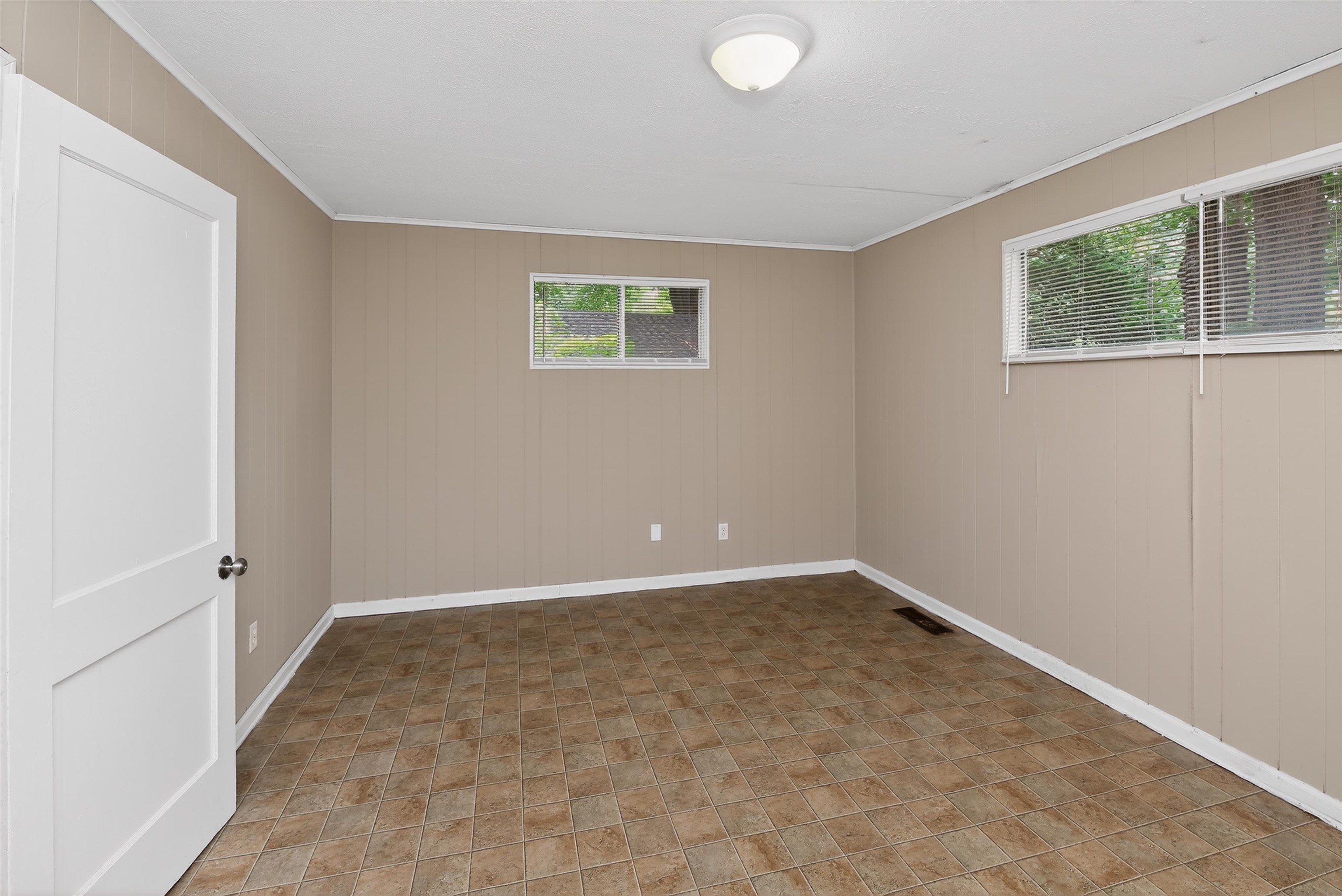 2840 Allen Road Memphis, TN 38128 - Photo 21 of 31 Spacious room featuring patterned tile flooring, light neutral-toned paneled walls, and white baseboards