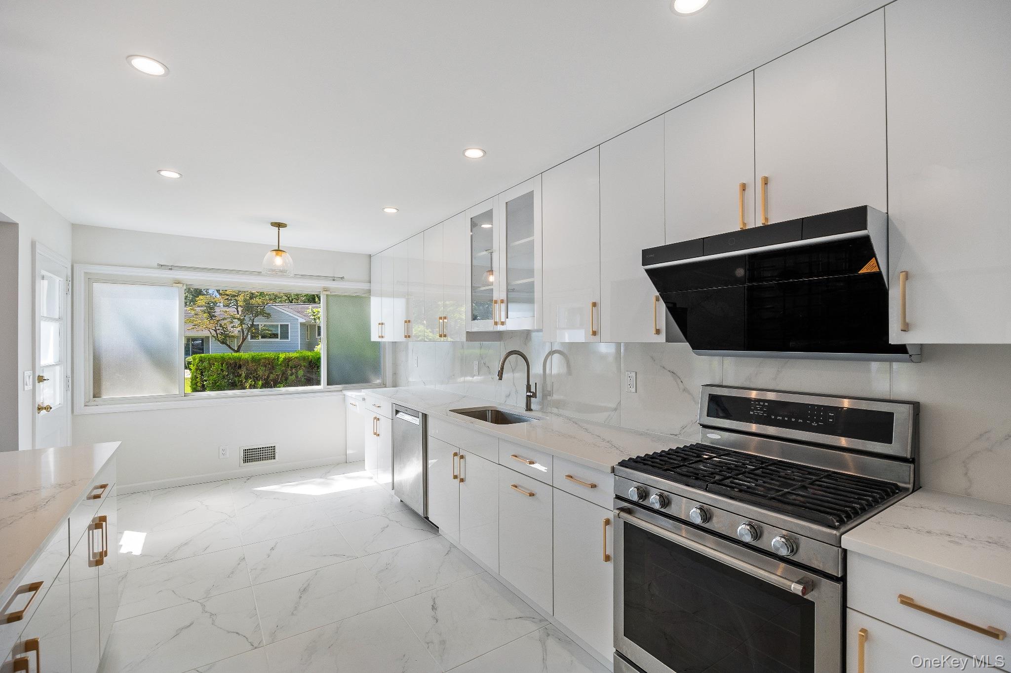 372 Heathcote Road Scarsdale, NY 10583 - Photo 4 of 20 Kitchen with appliances with stainless steel finishes, exhaust hood, light marble finish floors, backsplash, and light stone counters