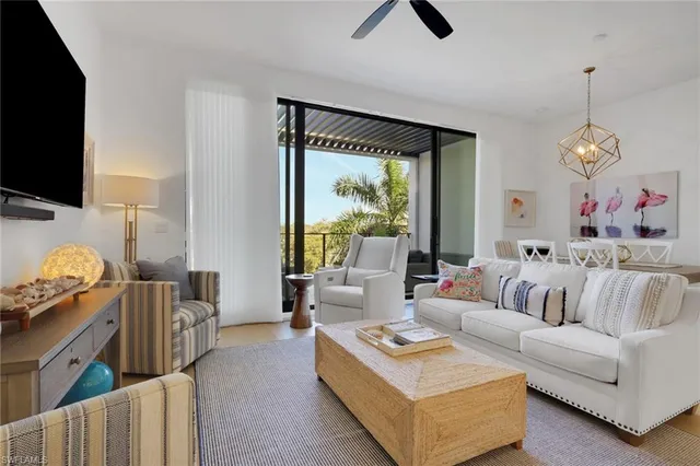 a living room with furniture a flat screen tv and a large window