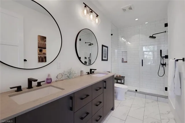 a bathroom with a double vanity sink mirror and shower