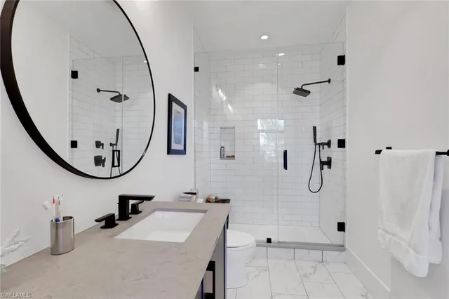 a bathroom with a sink a toilet and a mirror