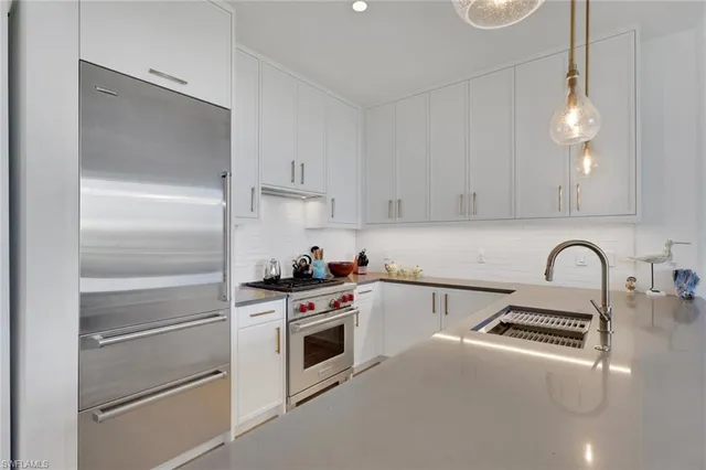 a kitchen with white cabinets and white appliances