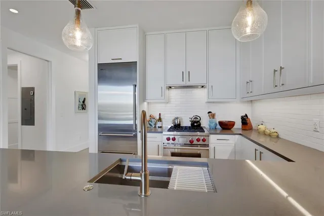 a kitchen with a refrigerator and a stove top oven