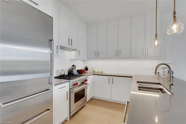 a kitchen with white cabinets stainless steel appliances and sink