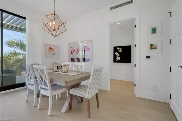 a view of a dining room with furniture a chandelier and a window