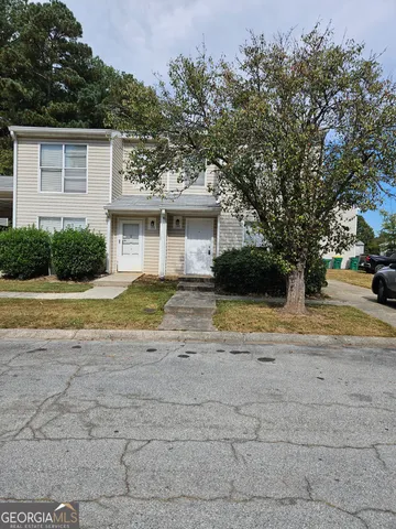 a view of a house with a yard and large trees