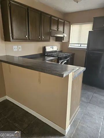 a kitchen with a refrigerator sink and wooden cabinets