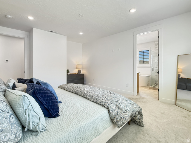 916 Rocky Mountain Way Elk Ridge, UT 84651 - Photo 22 of 54 Bedroom with light colored carpet, recessed lighting, a textured ceiling, and ensuite bath