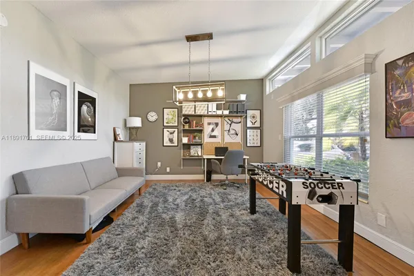 a living room with furniture a flat screen tv and a floor to ceiling window