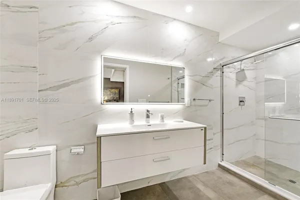 a bathroom with a double vanity sink mirror and shower