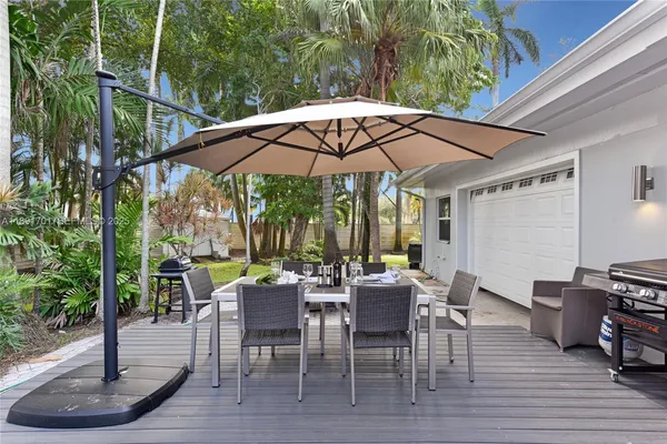 a view of a patio with a dining table and chairs under an umbrella