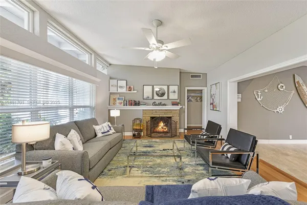 a living room with furniture fireplace and a large window