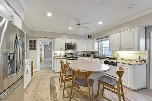 a kitchen with a dining table chairs refrigerator and cabinets