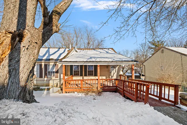 a view of a house with a yard and wooden fence
