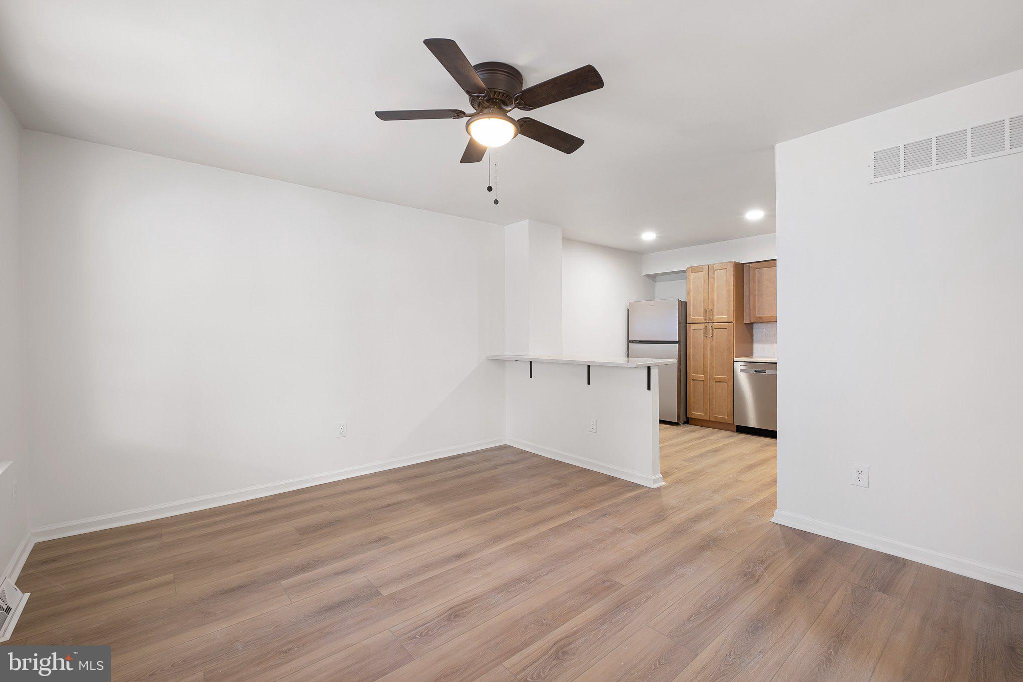 255 Prospect Avenue, Unit B Downingtown, PA 19335 - Photo 9 of 20 a view of an empty room with wooden floor and a ceiling fan