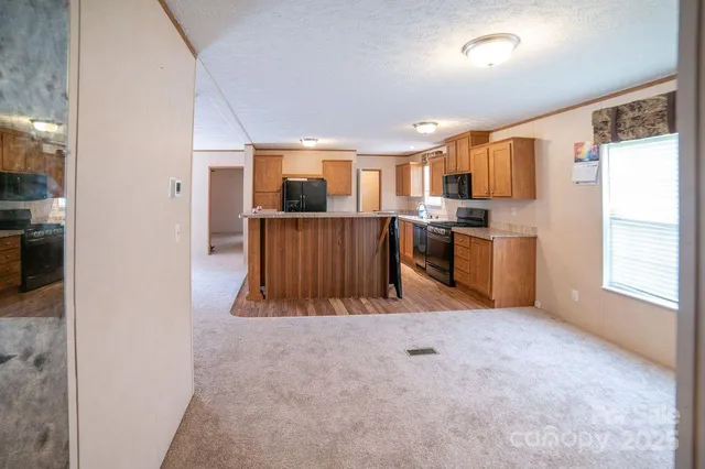 a view of kitchen with kitchen island wooden floor center island and stainless steel appliances