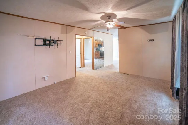 a view of a livingroom with a ceiling fan and window