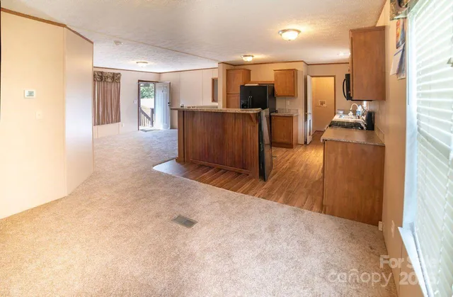 a view of a kitchen with refrigerator and a fireplace