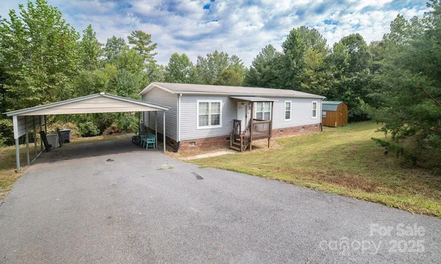 a view of a house with a yard and large tree