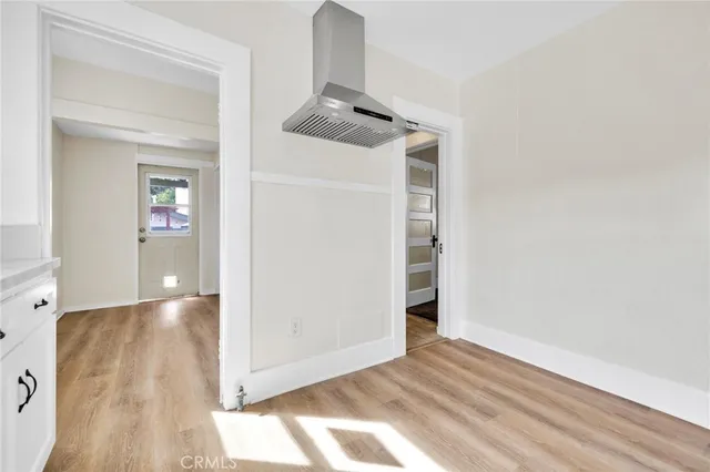 a view of a hallway with wooden floor and closet
