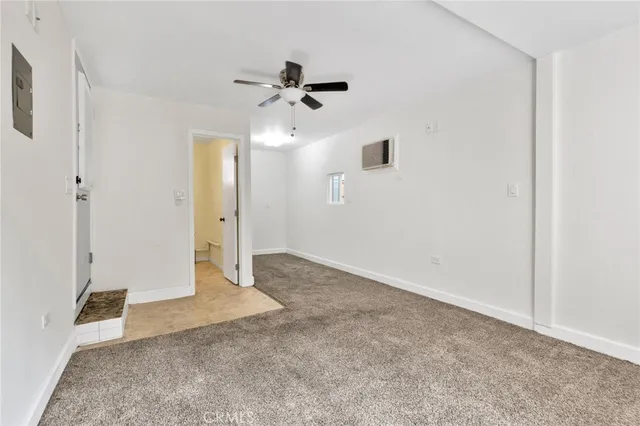 en empty room with ceiling fan and window
