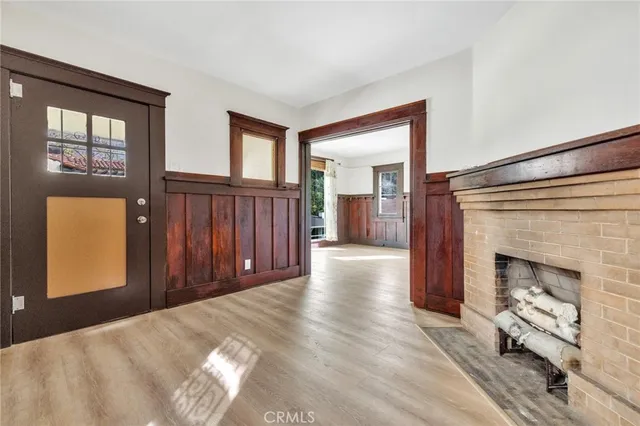 a view of a livingroom with wooden floor and a fireplace