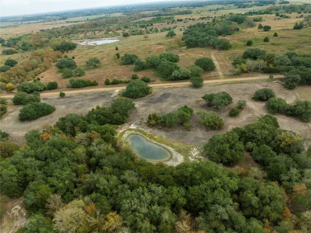 an aerial view of residential houses with outdoor space and trees