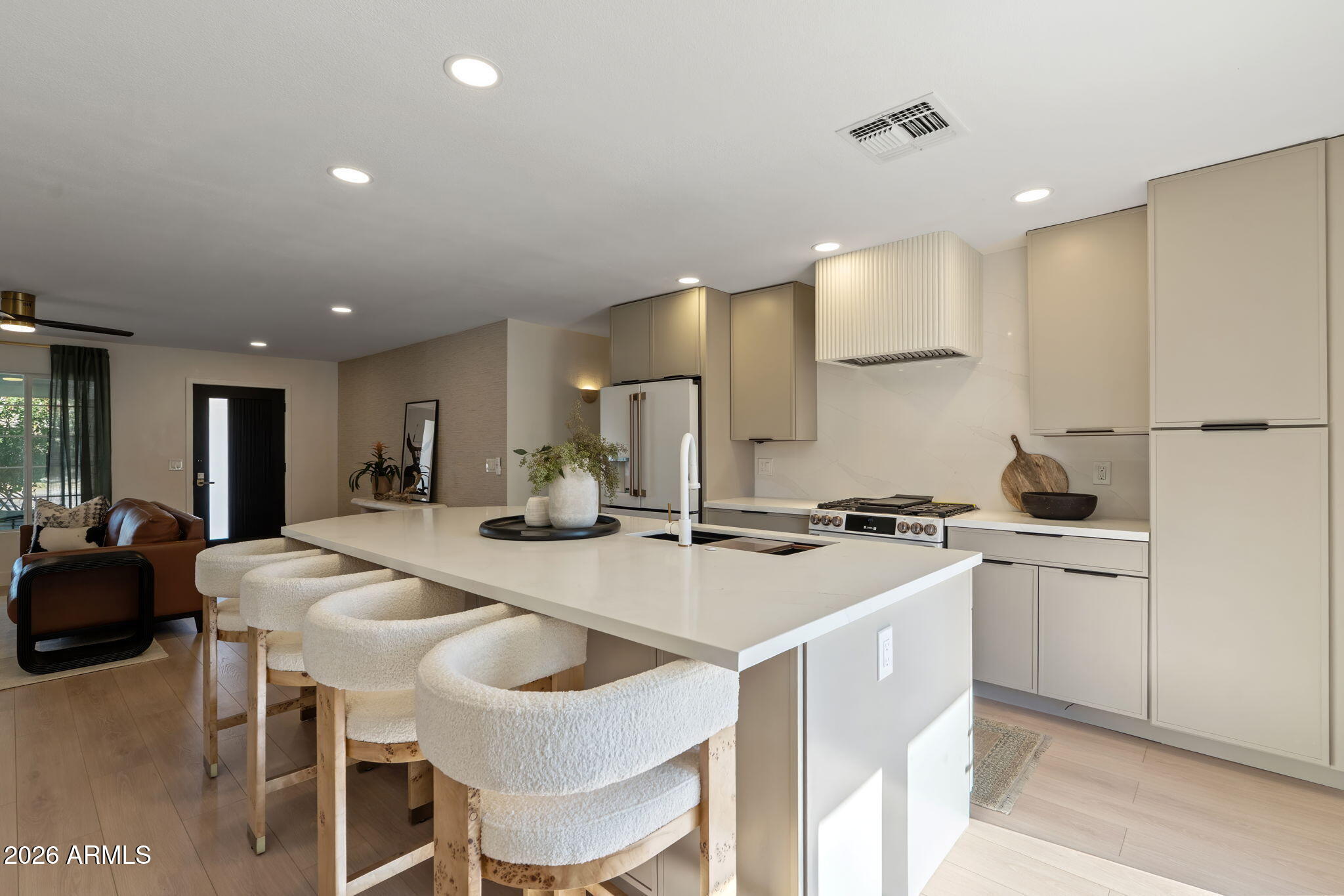 7255 East Coronado Road Scottsdale, AZ 85257 - Photo 11 of 55 a kitchen with stainless steel appliances granite countertop a stove a sink a refrigerator white cabinets and chairs with wooden floor