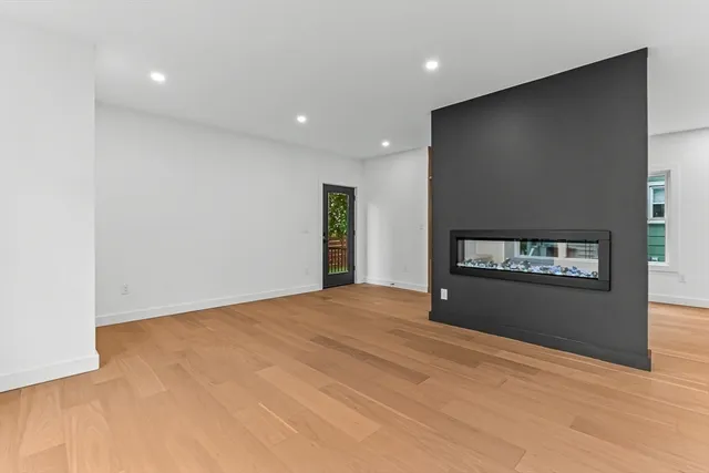 a view of an empty room with a window and a fireplace