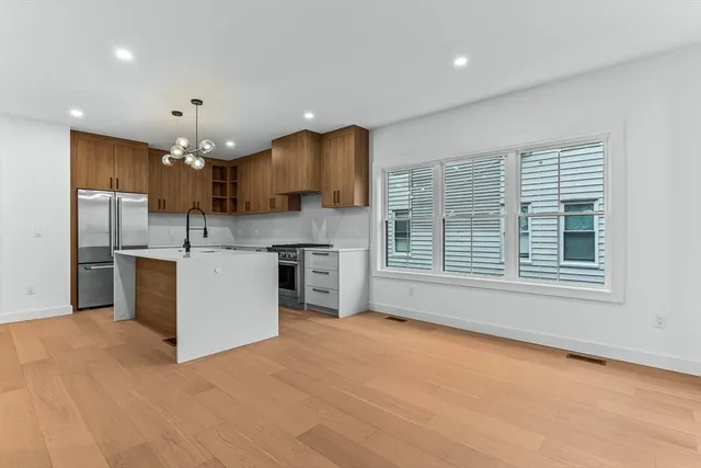 a kitchen with stainless steel appliances granite countertop a sink a stove a refrigerator and a cabinets