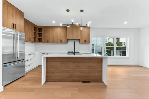 a kitchen with kitchen island a counter top space cabinets and stainless steel appliances
