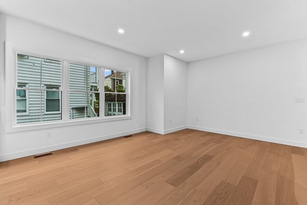 11 Bonner Avenue, Unit 2 Medford, MA 02155 - Photo 22 of 33 a view of an empty room with a window and wooden floor