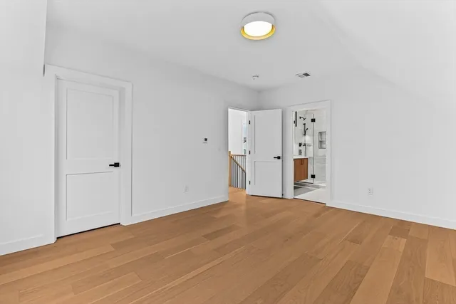 a view of empty room with wooden floor
