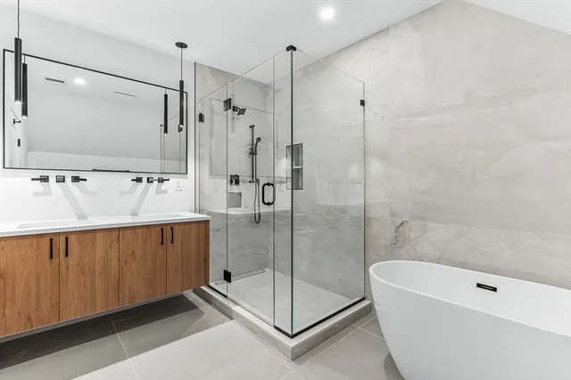 a bathroom with a tub a sink and glass door shower