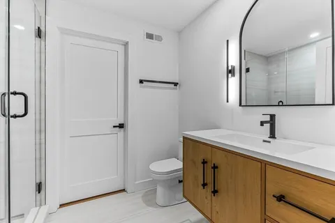 a bathroom with a granite countertop sink toilet and shower