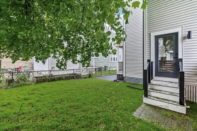 a view of a house with backyard and a tree