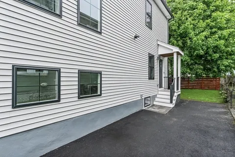 a view of a house with a yard and wooden fence