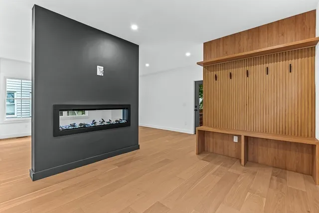 an empty room with wooden floor closet and windows